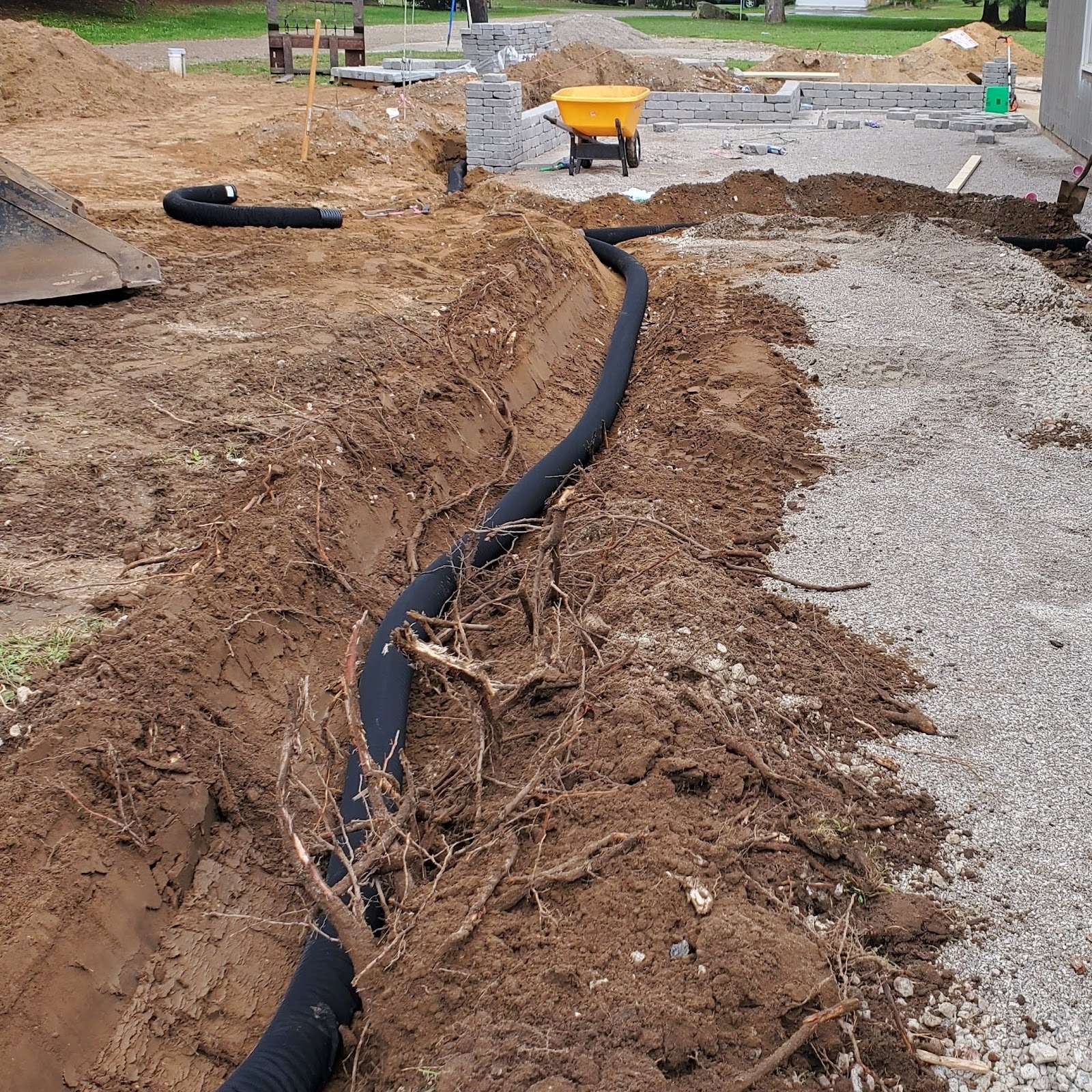 Black drainage pipe laid in a freshly dug trench