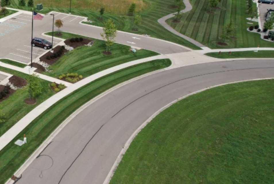 Aerial view of freshly striped lawn and mulched islands beside an office park parking lot