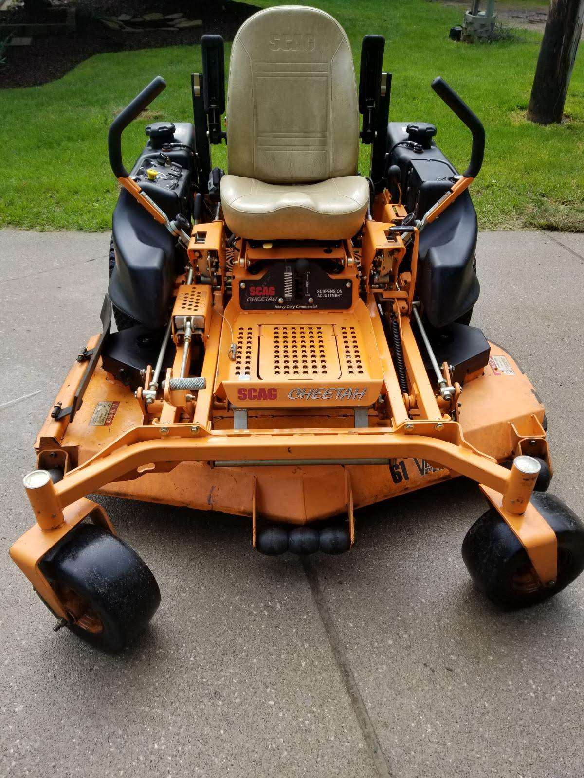 An orange Scag zero-turn mower parked on pavement