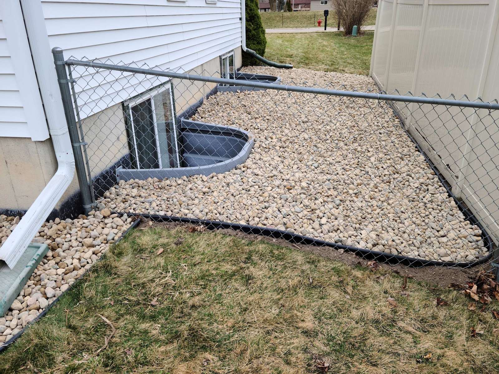 A pale stone landscape bed with black edging beside a building